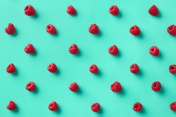 Colorful pattern of raspberries on blue background. From top view
