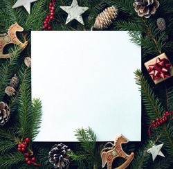 Creative frame of Christmas tree branches and decorations with square blank card. Top view. Xmas and New year concept