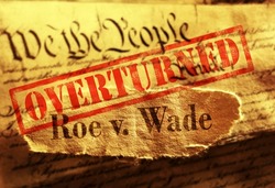 Roe V Wade newspaper headline with red Overturned stamp on the United States Constitution                               