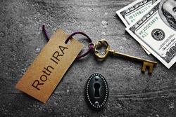 Gold key with Roth IRA tag, with keyhole and cash                               