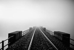 Railway disappearing into the fog. Black and white.
