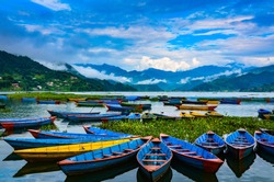 Colorful row boats docked on Lake Phewa in Pokhara, Nepal.