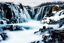 Incredible view of Bruarfoss Waterfall in winter. The 'Iceland’s Bluest Waterfall.' Blue water flows over stones. Midnight sun of Iceland. Visit Iceland. Beauty world.