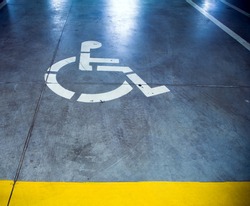 Disability sign in parking garage, underground interior
