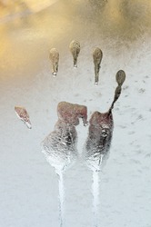 Hand trace on the frozen winter glass