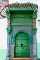 Richly decorated green door in Tanger, Morocco