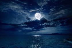 Night sky with full moon and reflection in sea, beautiful clouds. Elements of this image furnished by NASA