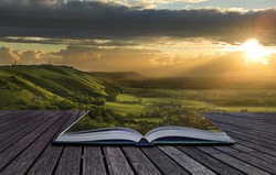 Beautiful sunset view across countryside spills out of magical book and creates stunning landscape background