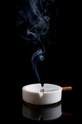 Cigarette in an ashtray on a black background