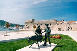 Statue of a man with a woman on a donkey near the Zora hotel, Primosten town, Croatia