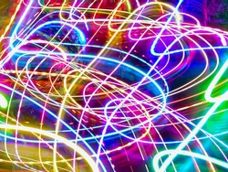 Looping light trails in an ornamental garden with LED lights for holiday illumination at night. Long exposure with motion blur. Light painting.