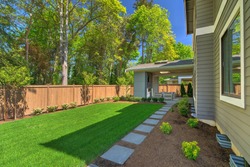 Fantastic new backyard with fresh landscape, fully fenced, with back porch, and large birch trees, steps and mulch.