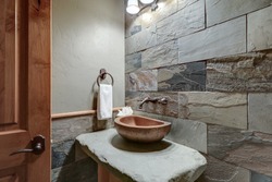 Absolutly stunning bathroom interior deisgn in a luxury rustic cabin style American home with stone and wood, venetian plaster and caling tones.