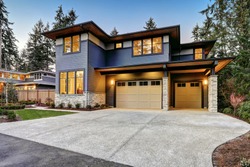 Luxurious new construction home in Bellevue, WA. Modern style home boasts two car garage framed by blue siding and natural stone wall trim. Northwest, USA