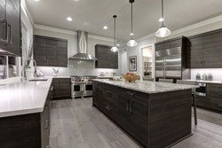 Modern gray kitchen features dark gray flat front cabinets paired with white quartz countertops and a glossy gray linear tile backsplash. Northwest, USA
