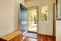 Small foyer with green open front door, laminate floor and wooden bench. Northwest, USA