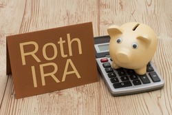 Having a Roth IRA plan, A golden piggy bank, card and calculator on wood background with text  Roth IRA