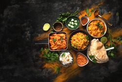 Assorted indian food on black background.. Indian cuisine. Top view with copy space