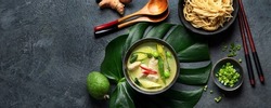 Green curry with chicken in bowl on dark background. Traditional Asian food. Top view, flat lay, copy space, panorama