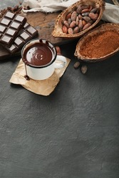 Melted chocolate drink on dark background. Hot beverage. Top view, flat lay, copy space
