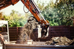 industrial backhoe excavator moving earth on construction site