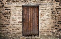 Ancient wooden door in stone castle wall. Tallinn, Estonia