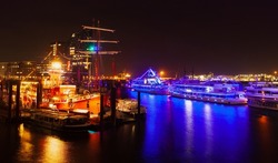Night city view with illuminated ships and floating restaurants moored in old port of Hamburg, Germany