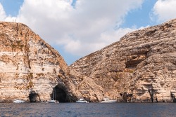Scenic coastal landscape with yachts and red rocks, Blue Grotto, Malta island