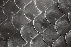 Scale body armour made of steel plates. Medieval knight armor close up photo with selective soft focus