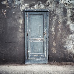 Old blue wooden door in dark concrete wall, empty abstract interior, square background texture