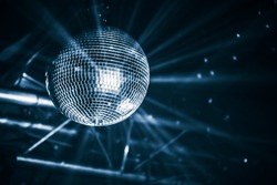 Disco ball with bright rays, blue toned night party background photo