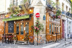 Bicycle is parked at typical Parisian cafes decorated for Christmas holidays in Paris, France