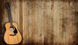 Acoustic guitar against an old barn background.