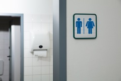 Public Restroom With Male And Female Toilet Sign On White Wall