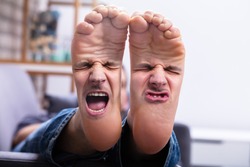 Close-up Of Man's Feet With Painful Facial Expression
