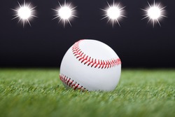 Baseball On Grass Field With Light In The Background