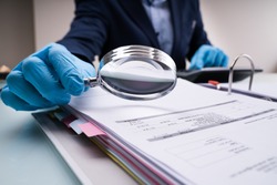 Business Fraud Investigation With Magnifying Glass In Gloves