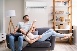 Happy Woman Holding Air Conditioner Remote Control