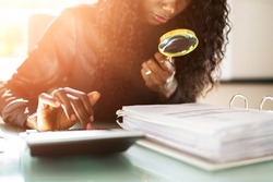 African American Corporate Tax Auditor Using Magnifying Glass