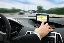Close-up Of A Person's Hand Using Gps Navigation System In Car