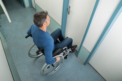 High Angle View Of A Man Sitting On Wheelchair Opening Door
