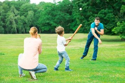Happy Young Family Playing Baseball At Park
