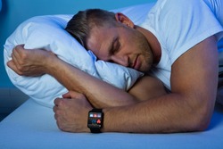 Man Sleeping With Smart Watch In His Hand Showing Heartbeat Rate