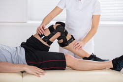 Close-up Of A Female Physiotherapist Giving Leg Exercise In Clinic