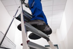 Close-up Of Man Standing On Steel Ladder