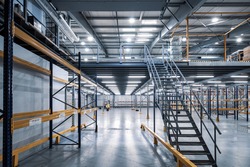 Modern interior of empty  industrial warehouse. New distribution storehouse. Metal construction. Staircase to second floor.