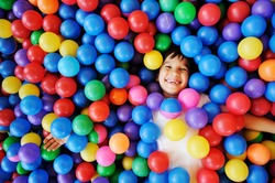 Happy children playing and having fun at kindergarten with colorful balls