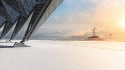 empty floor with wind farm and mountains in sunrise 
