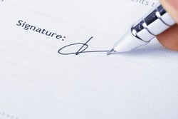 closeup of the signature and pen on a document paper 