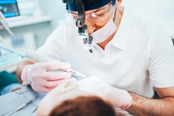 Dentist cleans tooth canals of patient and removes nerve - pulpitis treatment